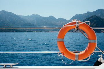 Ring life boy on big boat. Obligatory ship equipment. Personal flotation device. Prevent drowning. Orange lifesaver on the deck of a cruise ship. Traveling summer vacation concept