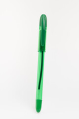 A vibrant, translucent green ballpoint pen is prominently displayed against a clean, white background.