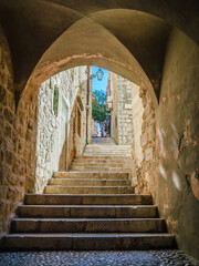 Famous narrow street and old city walls in Dubrovnik, Croatia