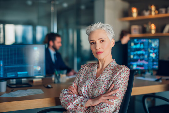 Middle-aged Caucasian business woman sitting in her office, conducting a meeting with her colleagues