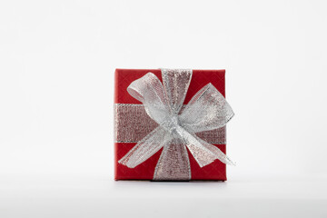 Red gift box, perfectly square, sits elegantly against a pristine white background, promising anticipation and delight.