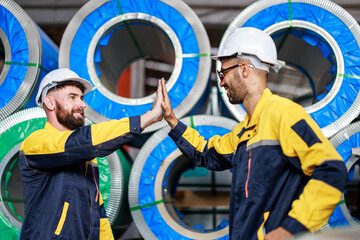 Technician industrial worker hi five after inspecting aluminum metal sheet fabricating roll check...