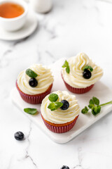 Cupcakes, muffins decorated with cream, berries and green mint leaves. Delicious homemade dessert....