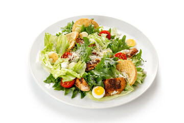 Caesar salad with roasted chicken meat, tomatoes, croutons and parmesan cheese isolated on white background with clipping path, cut out.