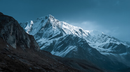 Majestic snow-covered mountains bathed in the warm light of sunrise with dramatic clouds, creating a stunning and serene alpine landscape