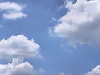 A wide view of white fluffy clouds in a blue sky
