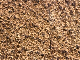 Close-up of rough brown and black textured stone wall