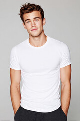 Fototapeta premium A beautiful male model wearing a tight small size white t-shirt. A product shot for fashion and apparel. best use for mockup