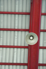 Industrial ceiling with red beams and corrugated metal panels overhead