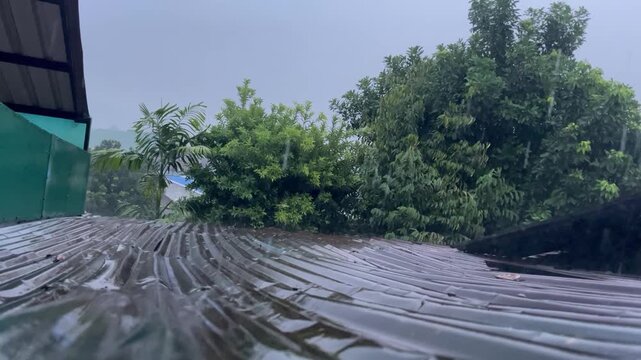 Rainwater flowing over the roof tiles seen up close.