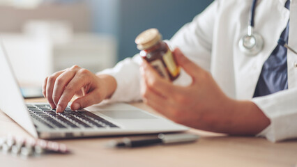 Hand of doctor checking data on medicine pill