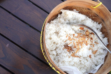 Steaming bowl of white rice topped with crispy fried shallots, ready to serve.
