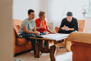 Three family members enjoy spending quality time together playing games around a wooden table,...