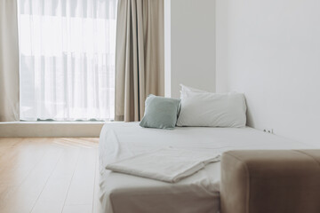 Soft daylight fills bright bedroom featuring wooden floor, soft furnishings, and natural palette. Comfort meets aesthetics in serene sleeping space.Scandinavian-style bedroom with beige curtains, wood
