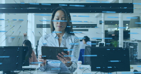 Holding tablet, woman wearing shirt guiding colleagues in modern office with monitors data overlays
