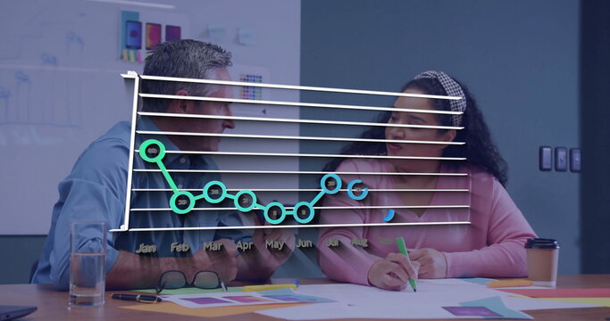 Analyzing line chart overlay with team reviewing color swatches and mockups at conference table