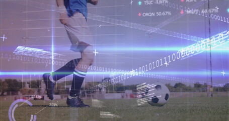 Female soccer player in blue jersey and cleats kicking soccer ball on field, with digital overlay