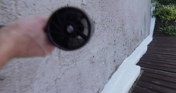 POV, blowing away garbage and leaves on the street with a turbo fan, vertical video