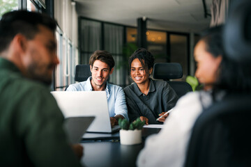 Multicultural professional businesspeople working together on research plan in boardroom.