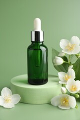 Cosmetic product and jasmine flowers on green background