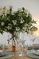 Bouquet of beautiful jasmine flowers on dining table indoors