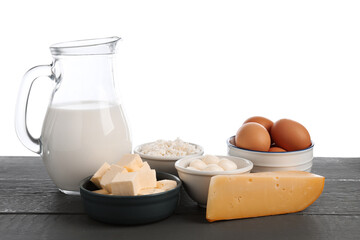 Different dairy products and eggs on grey wooden table against white background