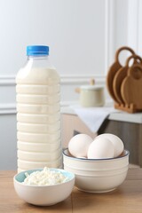 Different dairy products and eggs on wooden table indoors