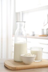 Dairy products. Fresh milk and cottage cheese on wooden table in kitchen