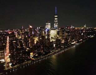 Obraz premium Vibrant New York City skyline at night with dazzling lights reflecting on the water