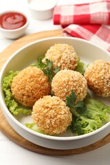 Delicious fried croquette balls with parsley and lettuce on white wooden table, closeup