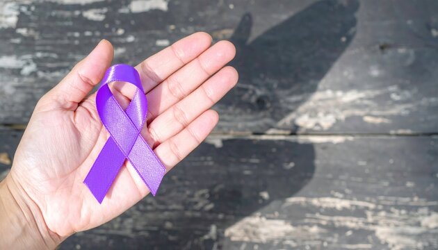 Hopeful purple ribbon held in hand symbolizing support and awareness
