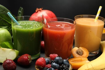 Superfood. Refreshing smoothies in glasses and ingredients on dark textured table against black background, closeup