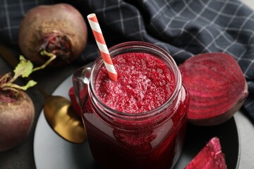 Superfood. Refreshing smoothie in mason jar and beetroots on dark table, closeup