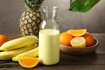 Superfood. Refreshing smoothie in bottle and ingredients on wooden table against grey background,...
