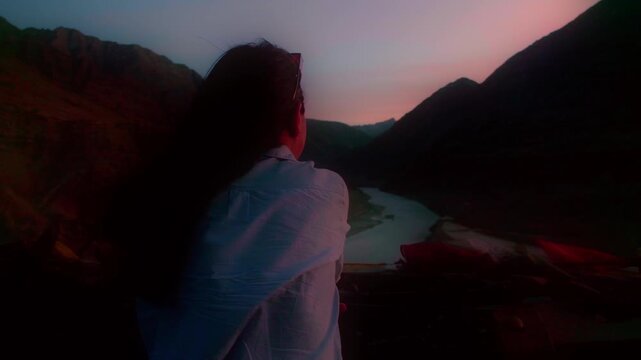 Silhouette of Girl look at scenic view of Sangam of Zanskar and Indus river in Leh, Ladakh during dusk - No face - Selective focus on mountains