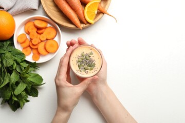 Superfood. Woman with tasty smoothie and ingredients at white table, top view