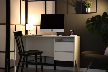 Stylish workplace with desk, computer and stationery at home office. Interior design