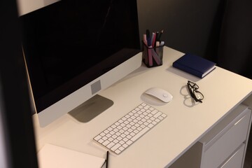 Desk with computer, stationery and glasses at home office, closeup. Interior design