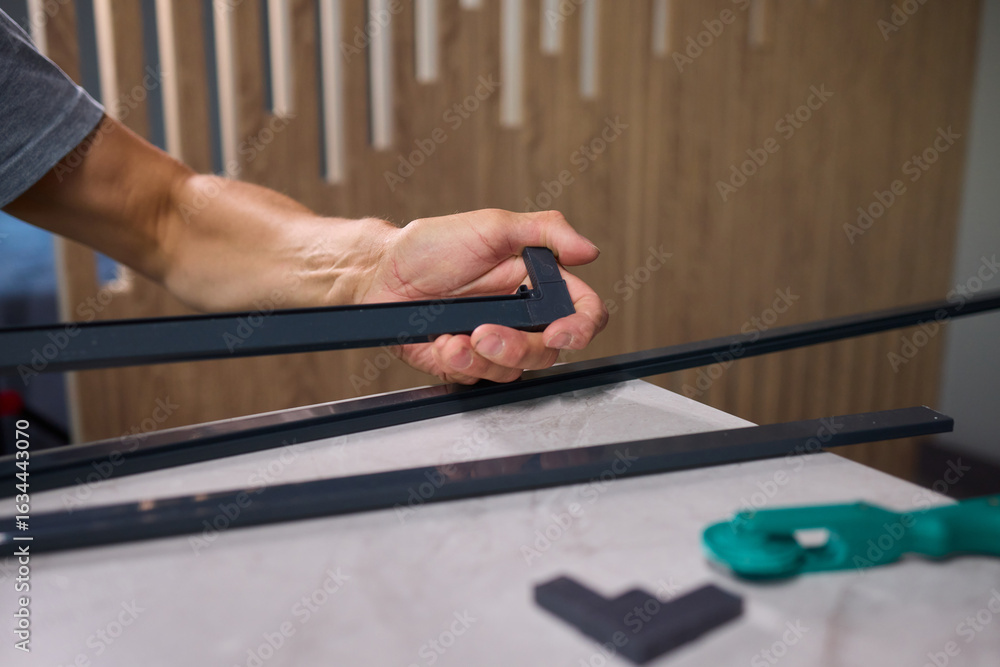 Aufkleber hand assembling a frame on a beautiful and modern table in a creative workspace