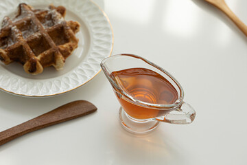 syrup in a bowl with waffle