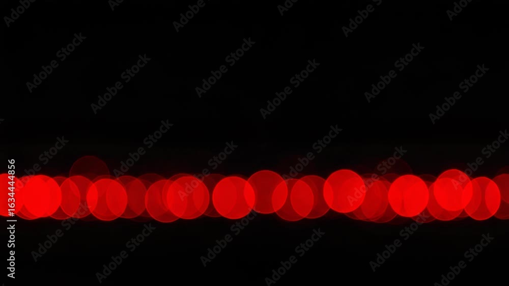 Poster red bokeh lights forming a horizontal line on a dark, abstract background