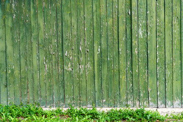 background of old weathered and cracked boards with peeling paint of green color