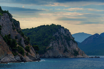 beautiful seascape, view of the sea and high cliff in the distance in the evening, near Petrovac city, Montenegro
