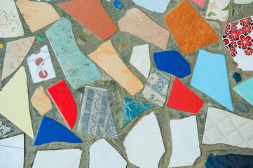 Rough concrete texture with ceramic mosaic made of broken tile pieces