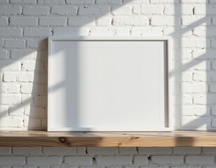 Clean white frame resting on a rustic wooden shelf against a textured white brick wall with soft sunlight patterns.
