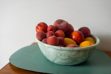 Fruit bown apricots nectarines peaches lemons pink red orange healthy food summer food white background