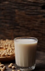 Soy milk with soybeans on wood background