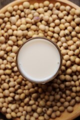 Soy milk with soybeans on wood background