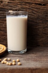 Soy milk with soybeans on wood background