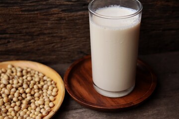 Soy milk with soybeans on wood background